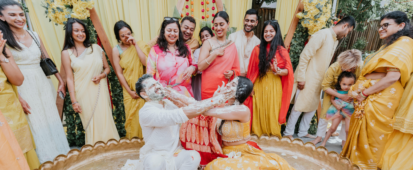 Manisha and Saketh haldi ceremony with family group smiling during traditional Indian wedding ritual