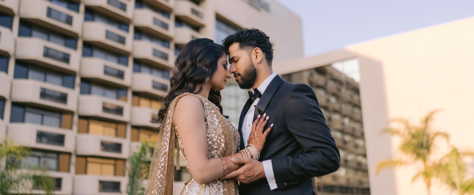 Indian wedding reception couple dance at DoubleTree San Jose with bride in gold lehenga and groom in tuxedo